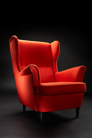 A Orange High-back chair on a dark background